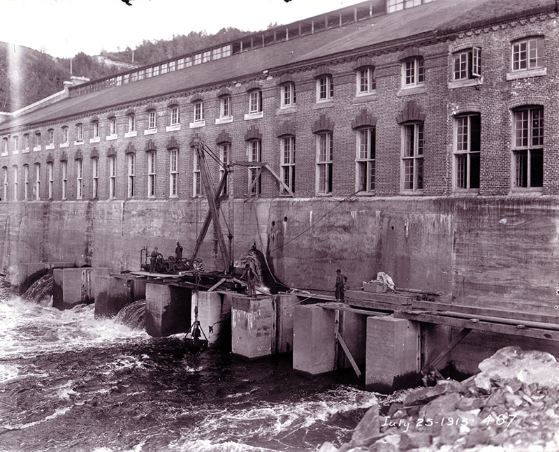 Employees doing maintenance work on the walls of the Shawinigan-1 generating station