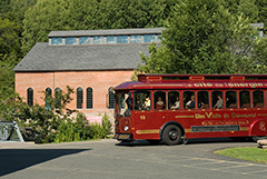 L'autobus de style tramway s'apprête à descendre des visiteurs au secteur historique.