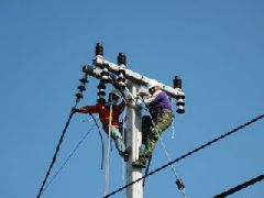 Two workers at work at the top of a distribution network pole