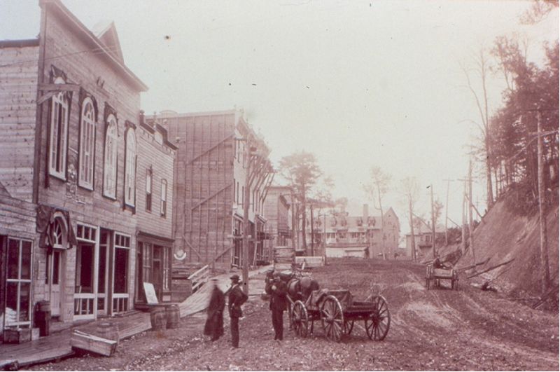 People standing in front of a business under construction on Rue de la Station (Street)