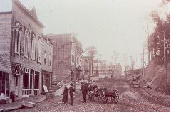 People standing in front of a business under construction on Rue de la Station (Street)